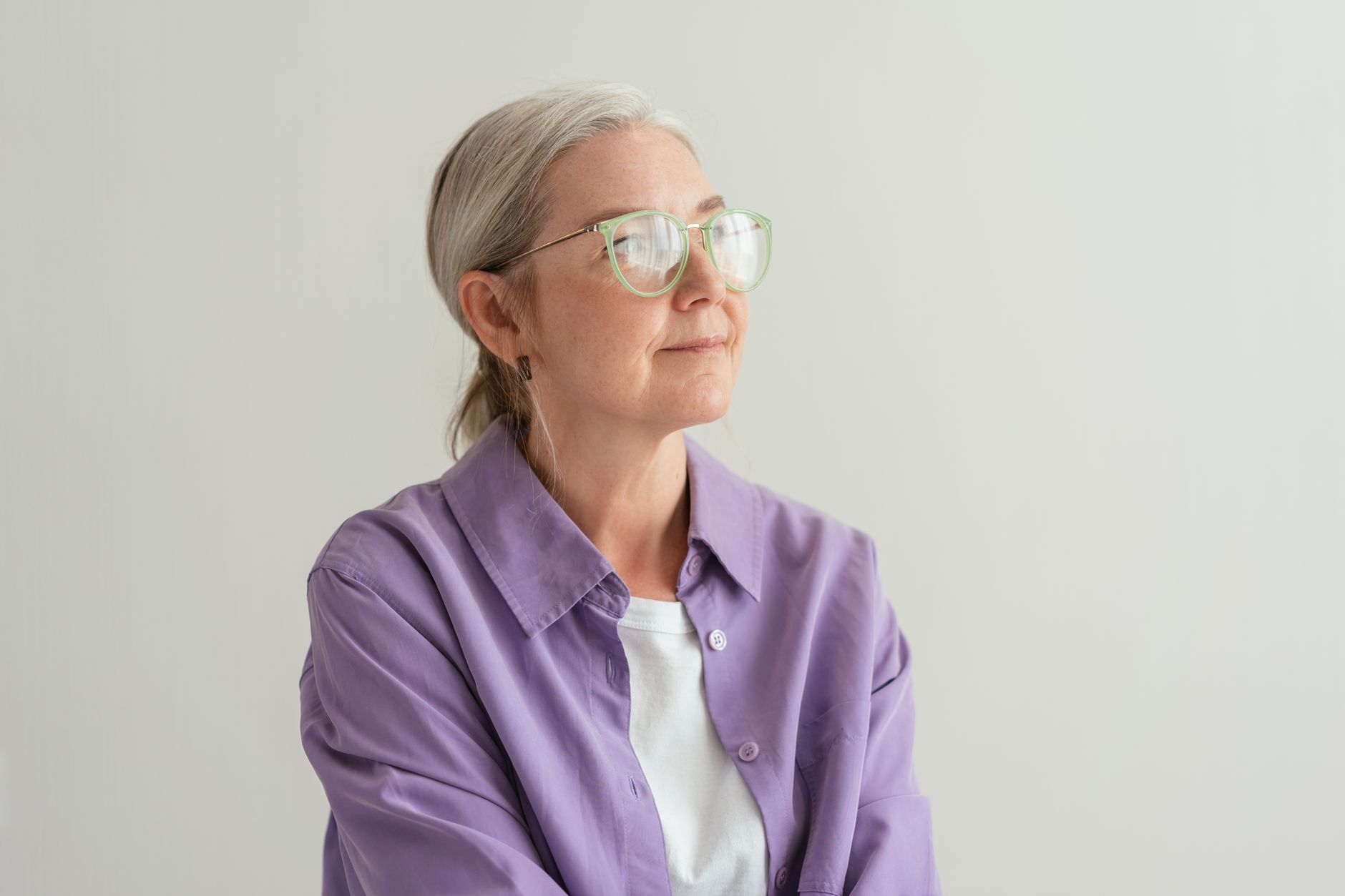 A calm, confident older woman looking thoughtfully into the distance
